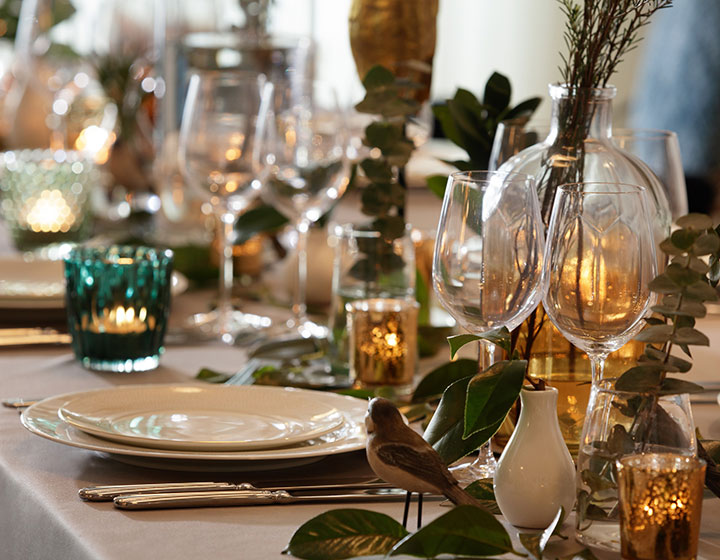 Close up of table set with candles, flowers, cutlery, glasses, and dishes for an event at Kimpton Palladian Hotel